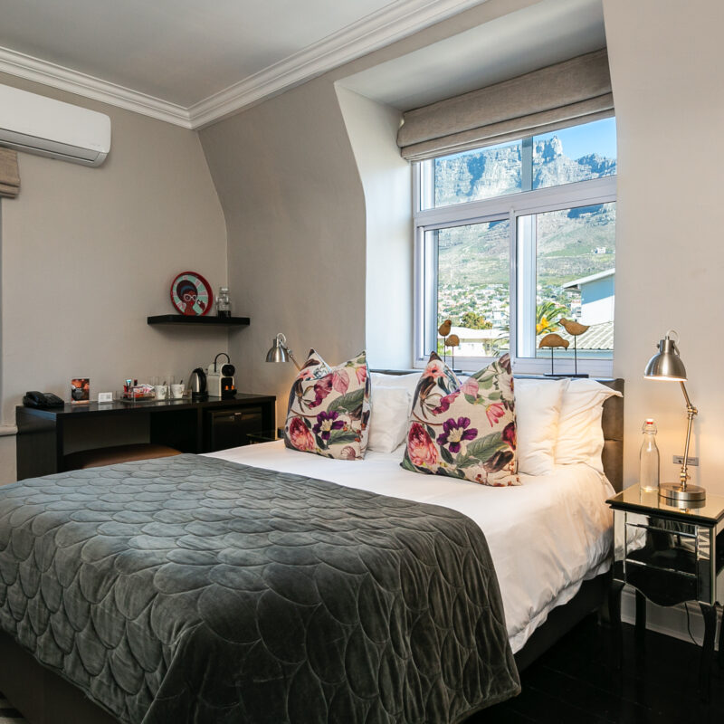 An elegant Cape Town hotel bedroom with a window offering a beautiful view of Table Mountain.